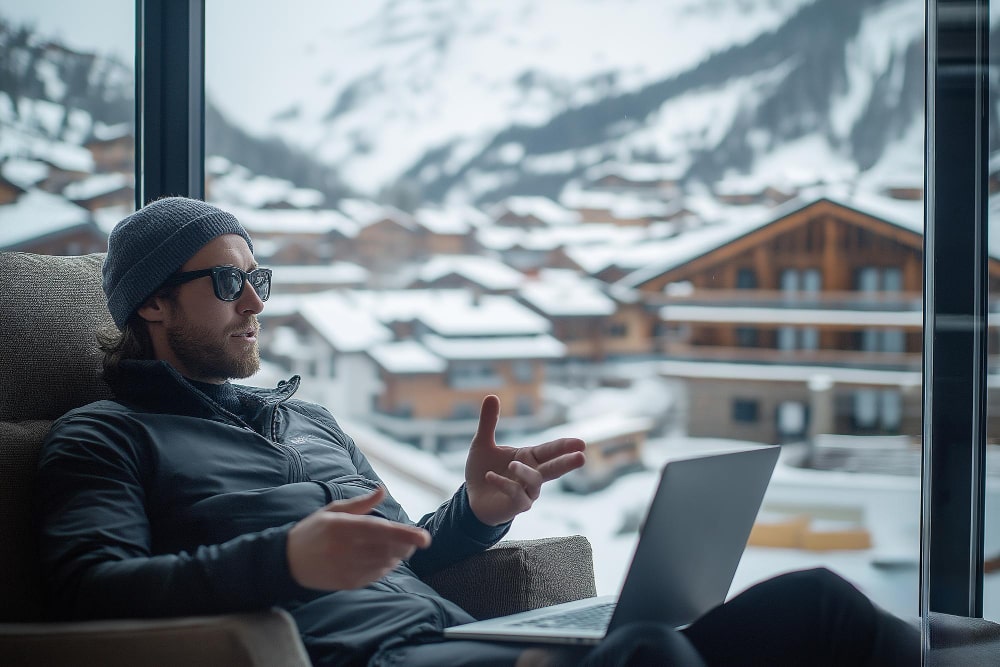 Mann arbeitet remote mit Laptop vor beeindruckender Bergkulisse – produktiv bleiben mit eSIM Schweiz